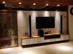 an entertainment center with speakers and a large tv on top of the cabinet in front of it