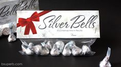 silver bells wrapped in foil with a red bow