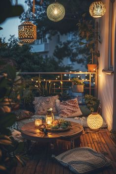 an outdoor patio with lights hanging from the ceiling and pillows on the floor next to it