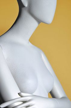 a white female mannequin with her hands on her hips and head tilted to the side