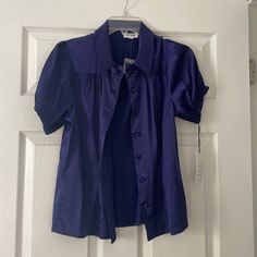 Dark Blue Super Soft Satin Vintage Shirt From Unique Vintage. Button Up, And Elastic Sleeve Openings For A Ruched Sleeve Look. Wear Tucked In To A Pencil Skirt For A Cute Rockabilly Vintage Look. Blue Short Sleeve Blouse With Button Closure, Purple Short Sleeve Top With Button Closure, Blue Short Sleeve Top With Snap Buttons, Purple Short Sleeve Blouse With Buttons, Blue Short Sleeve Tops With Snap Buttons, Purple Short Sleeve Button Blouse, Formal Blue Short Sleeve Blouse, Collared Blue Blouse With Button Closure, Blue Collared Blouse With Button Closure