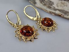 Welcome to handmade Baltic Amber jewelry shop. This Item is made of genuine, natural Amber. This item will make You look simple but gorgeous. Sun shape earrings. Brown Baltic amber jewelry. Amber earrings, lever back closure. Real gemstone dangle earring. Crystal hanging earrings. Flaming sun shape.  Each pair color is slightly different. Gold plated sterling silver 925.   Length: about 3,3 cm Our handmade jewelry is made with passion and love. If you have any problems with your order please contact us. Please note that colors can vary from originals depending on computer monitor's settings. Due to amber is being unique and natural gemstone, each item may be slightly different in shades or shapes. Items may have natural imperfections like lines and spots, specks, coloration and inclusions,