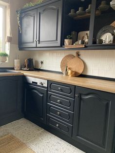 a kitchen with black cabinets and wooden counter tops