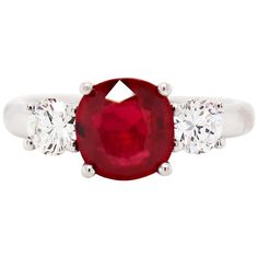 an oval cut ruby and diamond ring with three stones on each side, set in white gold