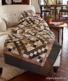 an image of a couch with a quilt on it