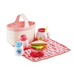 a picnic basket with food and drinks on a checkered table cloth next to it