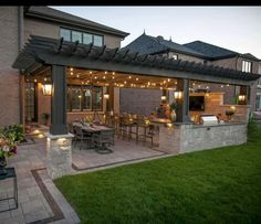 an outdoor kitchen and dining area is lit up at night