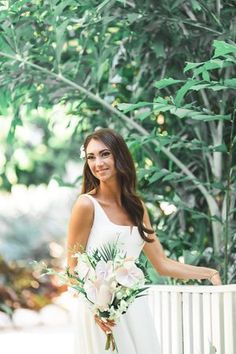 a woman in a white dress holding a bouquet