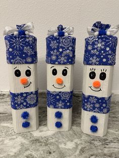 three snowmen wrapped in blue and white paper