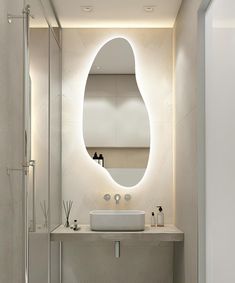 a bathroom with a sink, mirror and lights on the wall above it's counter