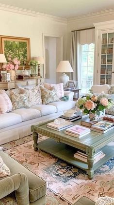 a living room filled with lots of furniture and flowers on top of a coffee table