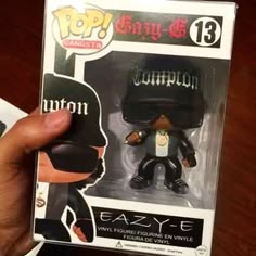 a person holding up a black vinyl figure