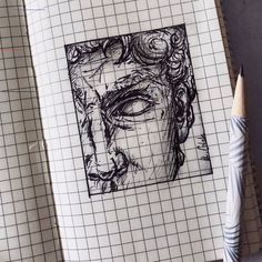 a pencil drawing of a man's face on a piece of paper next to a pen