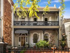 an old victorian house with wrought iron railings