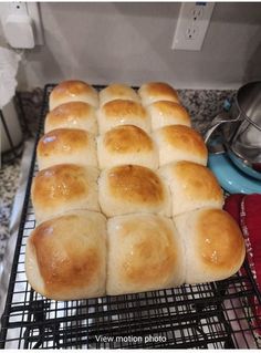 a bunch of rolls sitting on top of a cooling rack next to a microwave oven