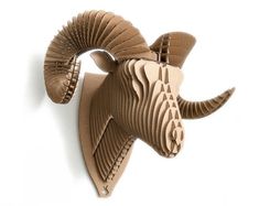 an animal head made out of cardboard on a white wall next to a pair of scissors