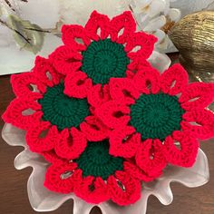 crocheted red and green flowers in a white bowl