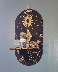 a shelf with some items on top of it and a sun above the moon in the sky