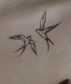 two small birds flying next to each other on a white sheet with black ink in it