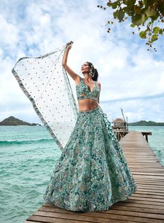 Crafted with meticulous attention to detail, the lehenga features intricate embroidery, delicate embellishments, and luxurious fabrics that drape gracefully against the body. Each element is thoughtfully designed to create a silhouette that is both flattering and feminine, ensuring that you look and feel your best on your special day. Renting a turquoise blue colored lehenga offers the perfect blend of luxury and affordability, allowing you to access designer attire without the commitment of pur Blue Green Lehenga, Lehenga Stitching, Gown Photoshoot, Dress Hairstyle, Indian Fits, Cultural Wear, Embroidery Lehenga, Desi Vibes, Green Evening Gowns