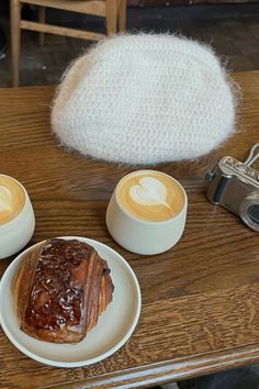 two plates with pastries on them sitting on a wooden table next to a camera