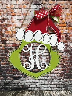 a christmas ornament hanging on the side of a brick wall with a bow