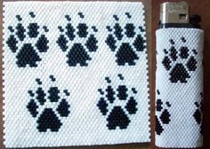 a cell phone case made out of perler beads with black and white paw prints on it