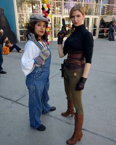 two women standing next to each other in front of a building