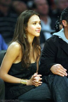 a man and woman sitting next to each other at a basketball game