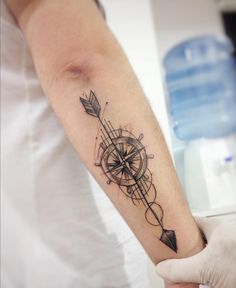 a person with a tattoo on their arm holding an arrow