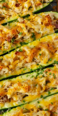 zucchini stuffed with cheese and other toppings on a baking sheet, ready to go into the oven