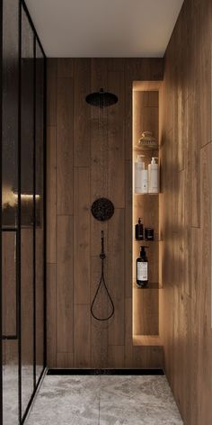 a bathroom with wooden walls and shelving on the wall next to it is a shower head