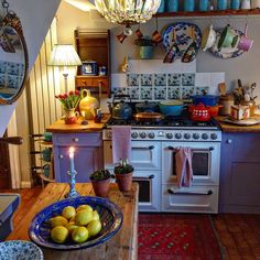 a kitchen filled with lots of counter top space and furniture next to a white stove top oven