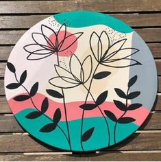 a painted plate sitting on top of a wooden table