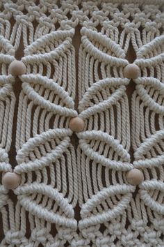 a crocheted tablecloth with wooden beads on it's edges and an intricate design in the middle