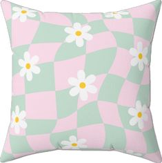 a pink and green checkered pillow with daisies in the center on a white background