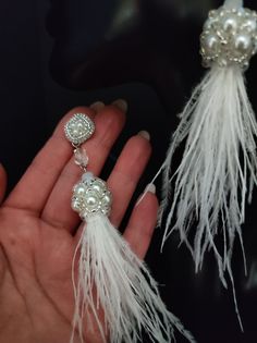 These beautiful earrings are made entirely by hand with beads and real ostrich feathers. The feathers are collected in a beautiful component created of pearls and beads. The pins are handmade with beadembroidery technique with beads and silver synthetic leather is applied from the back. The pin is connected to the tassel with a crystal bead. These earrings are quite long but are very light for the natural materials used. The white feathers and pearls give a very elegant and romantic look. These earrings are also perfect for your special day... a wedding or other important party. All jewels are delivered in a decorated box, ready to be given as a gift to your loved one. How to take care of your jewellery: put on your beauty products (cosmetics, perfumes, ...) before wearing your precious je White Feather Dangle Earrings, Handmade Tassel Earrings For Wedding, Elegant Feather Dangle Earrings, Elegant Dangle Feather Earrings, Elegant Feather Dangle Jewelry, Elegant Dangle Earrings With Feathers, Handmade Dangle Tassel Earrings For Wedding, Handmade Tassel Drop Earrings For Wedding, Elegant Feather Earrings For Gift