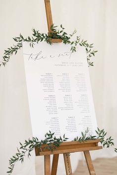 classic wedding table plan sign with green foliage on a wooden easel Seating Chart Wedding On Easel, Table Seating Chart Easel, Table Placement Ideas Seating Charts, Wedding Table Poster, Seating Chart Easel Wedding, Easel Seating Chart, Wedding Easel Ideas, Classic Seating Chart, Simple Wedding Seating Chart Ideas