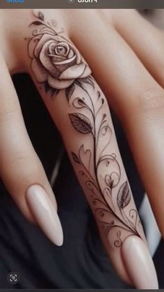 a woman's hand with a rose tattoo on it and an arrow in the middle