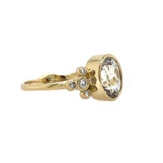 This beautiful oval Phenakite is set in 14k yellow gold atop Emily's signature freeform gold band. Accented by diamond clusters with 6 one point and 2 three point brilliant white diamonds. Makes for a unique alternative engagement or a luxurious right hand ring. Approximate center stone size: 9mm x 7mm Approximate CT weight: 1.55 CT Mohs Hardness: 7.5-8 This piece is handmade in our Hudson Valley studio. It is currently a size 8. ACCOMPANYING HALO BAND SOLD SEPARATELY. Oval Cluster Ring With Single Cut Diamonds, Oval White Topaz Rings With Single Cut Diamonds, Oval Yellow Gold Cluster Ring With Rose Cut Diamonds, Oval White Topaz Diamond Ring With Single Cut Diamonds, Timeless Oval Cluster Ring With Rose Cut Diamonds, Oval Cluster Ring With Bezel Setting In Fine Jewelry, White Topaz Diamond Accented Oval Ring, 14k Gold Cluster Ring With Bezel Setting, Oval Shape, Oval Rings With Single Cut Diamonds In 14k Gold