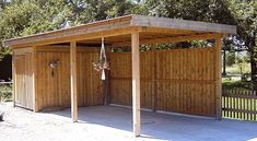 a wooden shed with two doors and a porch