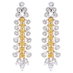 18 Karat Gold 13.31 Carat Yellow and White Diamond Solitaires Cocktail Earrings An imperial pair of earrings that exudes royalty and showcases the finest craftsmanship, this pair features 'Intense Yellow Diamonds'. Designed in an exquisite drop style, it features 7 Yellow Cushion-Cut Diamonds set in prong settings. Each yellow diamond consists of a Pear-Shaped Solitaire Diamond on either side. The top stud creates a dramatic look with two pairs of Solitaire diamonds with one diamond placed above Luxury Yellow Diamond Drop Earrings, Luxury Yellow Diamond Cut Earrings, Luxury Yellow Diamond Earrings For Wedding, Luxury Yellow Gold Chandelier Earrings For Anniversary, Formal Yellow Earrings With 17 Jewels, Yellow Earrings With 17 Jewels For Formal Occasions, Luxury Yellow Cubic Zirconia Earrings, Luxury Yellow Earrings For Wedding, Yellow Diamond Earring