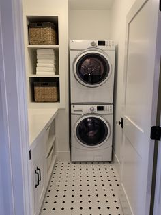 a washer and dryer in a small room with black and white flooring