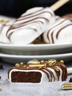 there is a piece of cake on the plate with chocolate and gold decorations around it