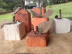 four cement blocks are stacked on top of each other in front of a large house