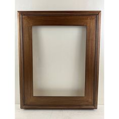 an empty wooden frame on a white wall