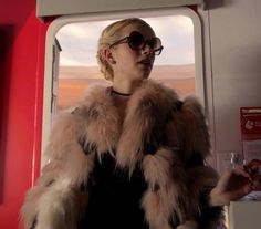 a woman wearing sunglasses and a fur coat