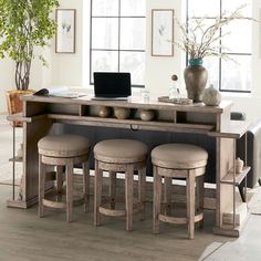 a dining room table with stools and a laptop computer on top of the table