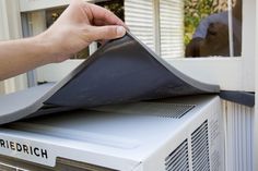 a person is opening the air conditioner with their hand to check it out outside