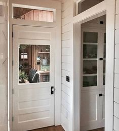 the inside of a house with two white doors and windows on each side of the door